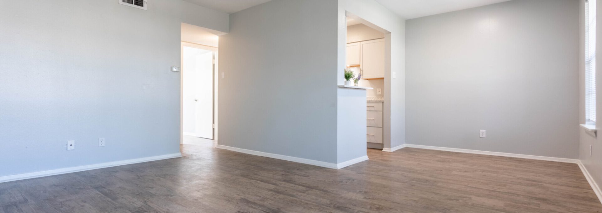 Spacious One Bedroom living and dining area flooded with natural light. Vinyl plank flooring with tow tone paint and updated LED lighting creates an inviting modern feel.